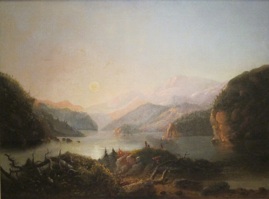 A still mountain lake ringed by the peaks of the Wind River Range.